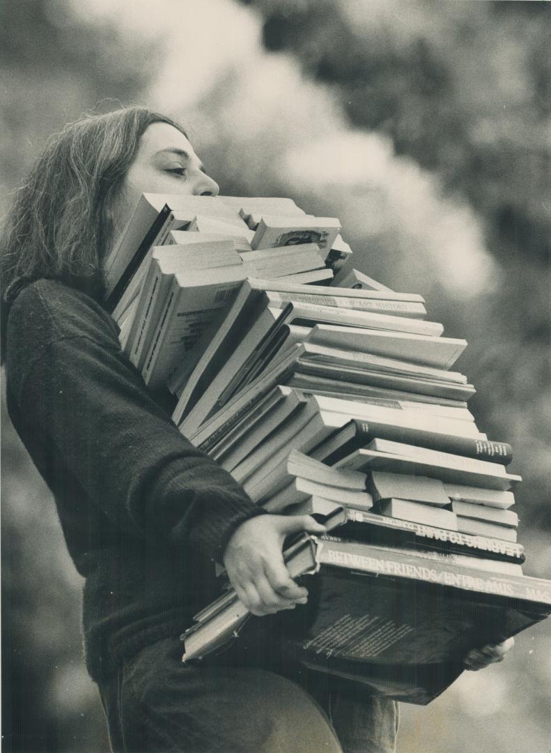 Tons of tomes up for sale. Deborah Schlow lugs a load of books to Trinity College's Friends of the Library annual book sale. thousands of books at bar(...)