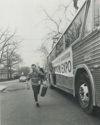 Robert Horton, 10, of Winona Dr. runs to catch bus for Expo he almost missed because his parents forgot to put clock ahead when time changed Sunday morning