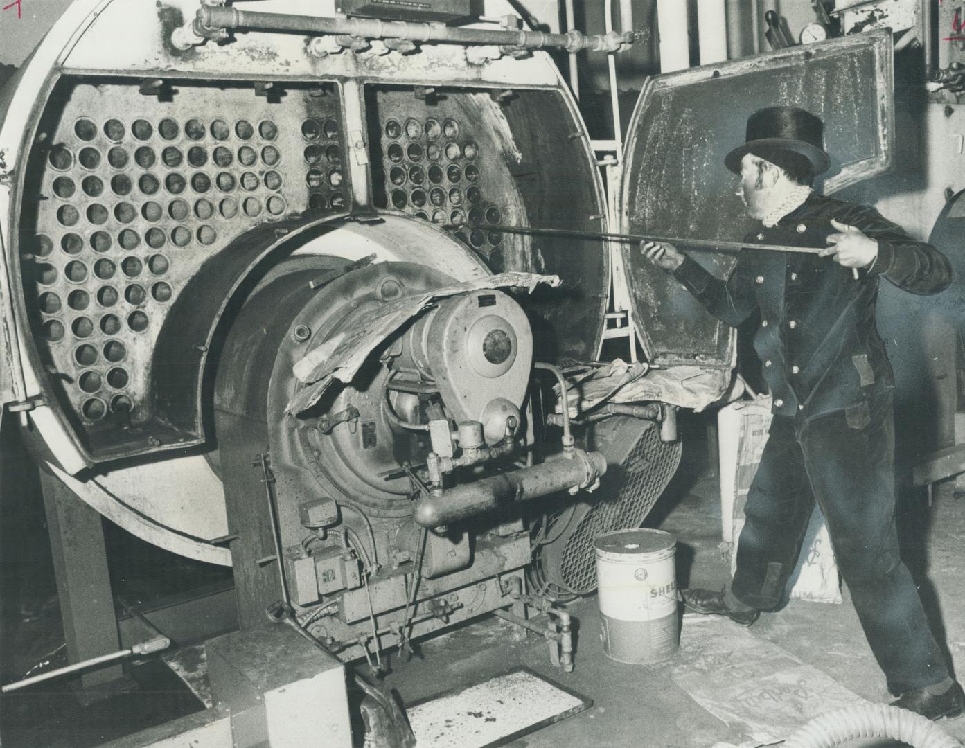 Chimney Sweep Norman Lenz cleans out a boiler in an apartment building on Shuter St