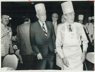 Leading a parade of Progressive Conservative members of Parliament to breakfast today, retiring party leader Robert Stsanfield wears chef's hat and ap(...)