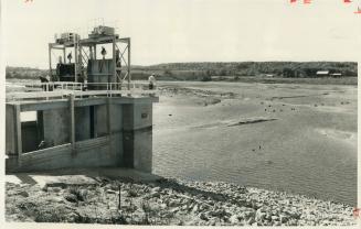 80 Acres of Glistening Clay lie below workmen repairing the sluice gates on the Kelso Conservation Area dam