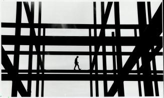 Lonely work. Welders and painters are at work on a three-storey Tippet-Richardson Ltd. warehouse, going up on Queen St. E., near the Don Valley. Busin(...)