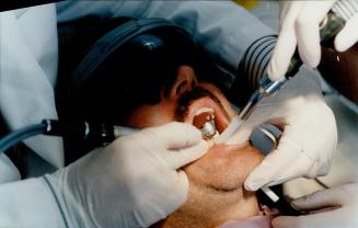 Open wide: Patient Larry Stevens enjoys a virtual reality video while Dr. Ron Weintraub does some work on his teeth