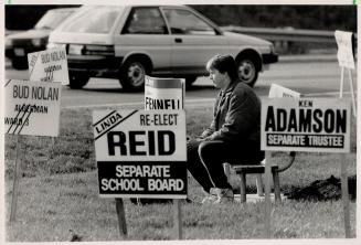 Surrounded by signs. Brian Smith of Brampton may be ponder his choices in the Nov. 14 municipal election while taking a break at the corner of Highway(...)