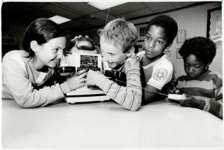 Omnibot: Eva Maria Strongylos, 9, Marcin Lempka, 9, Lee Solomon, 9, and Cybil Thompson, 4, play with the walking, talking robot at Flemingdon Gateway Computer Connection