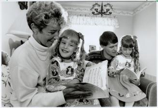 Passion for print: Charilyn Wright reads to daughter Christiann, 4, while dad Michael shares a classic with Jennalyn,7