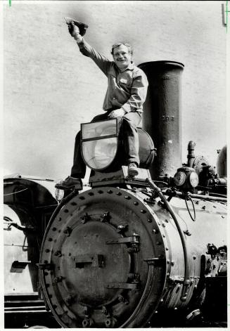 Riding high, Guy Sanvido straddles one of two old steam locomotives that will be parked on Queen's Quay for the next year to be refurbished as a tourist attraction for the Collingwood area