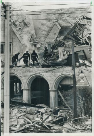 Still smoldering fires are fought by firemen in the blasted-out servant quarters above the garage of the Rosedale home of banker F. William Nicks. It (...)