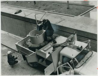 Bomb disposal man slowly lowers the suitcase into the armored rear of the bomb disposal squad's special truck which took it to Cherry Beach where the (...)