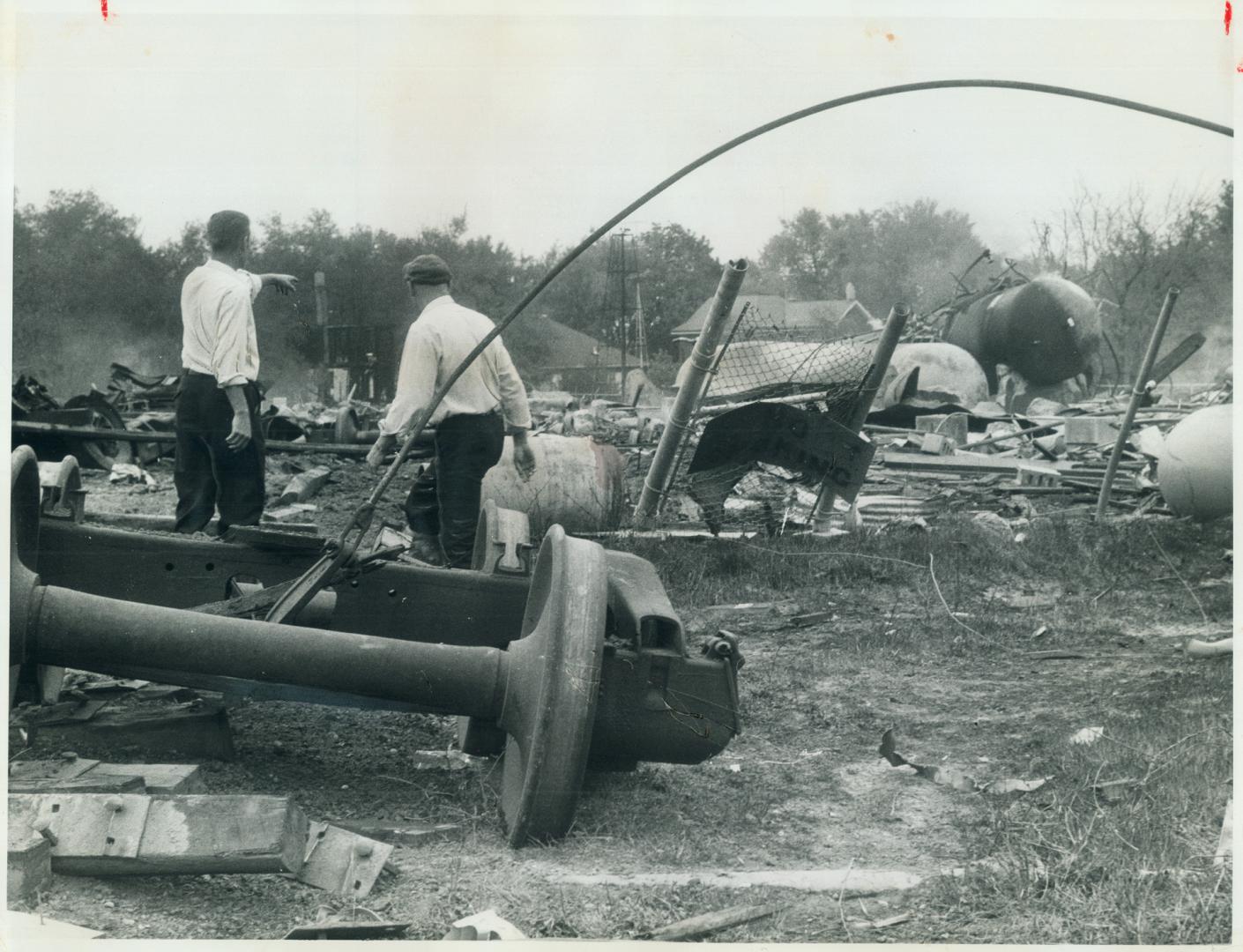 Twisted wreckage is strewn around by blasts which tossed tons of steel like confetti