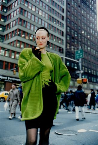 Poison green ribbed cocoon cardigan over matching sweater with drawstring detail at front and black wool knit skirt