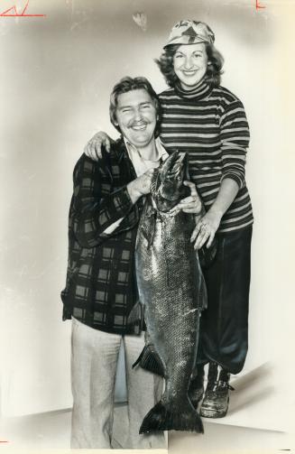 Sweet catch. Joan Ellenor of Oshawa used a marsh-mallow as bait to catch this 42-pound salmon near Duffins Creek, Pickering. Husband Neal hoists the Chinook