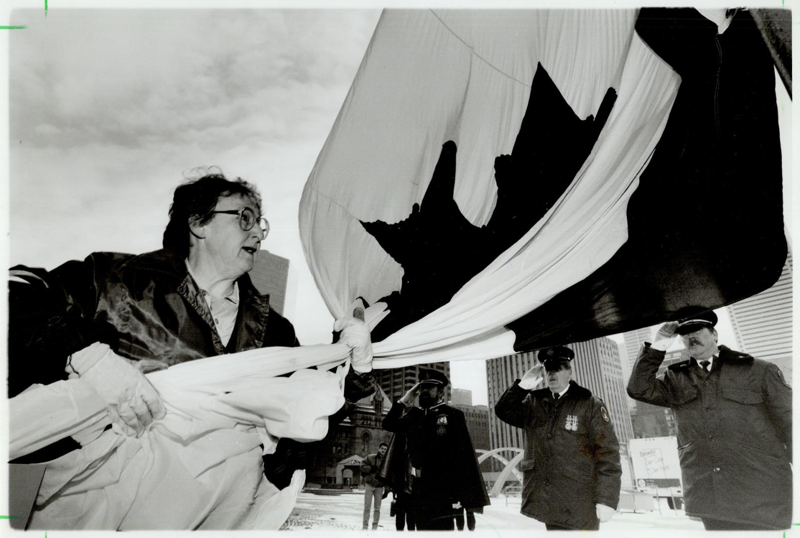 City of Toronto employee Marina Finch has the honor of unfurling the Canadian flag during Flag Day ceremony at city hall yesterday while the national anthem is played