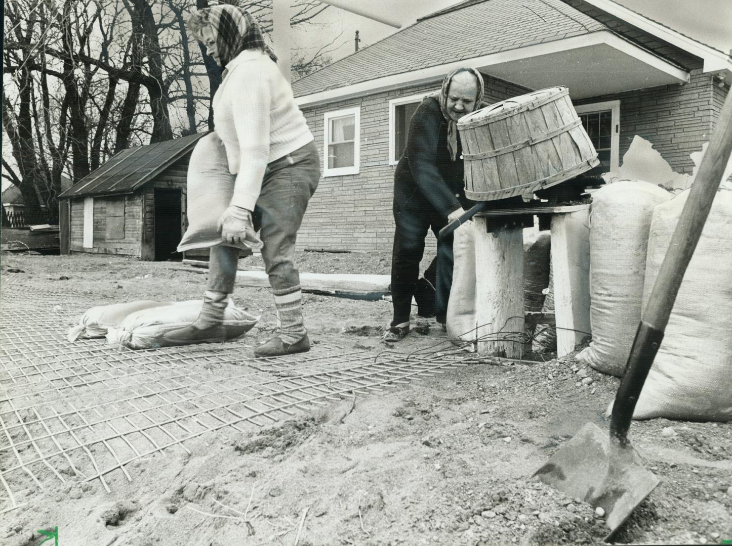 On the shore of Lake Erie, Eva Malolepszy and Nora Srokosz fill and stack sandbags outside their home in Harich Township as the already-high lake threatens houses