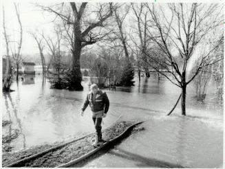 Fighting floods: Firefighters' hoses carry water from basements in the tiny village of Churchville flooded when the Credit River, blocked by ice floes, backed up Saturday night