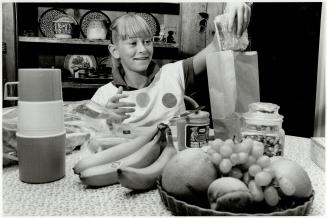 Power-packed: Kenne Ryan, 12, prepares a school lunch with her favorites - wholesome sandwiches, trail mix, fruits and raw vegetables