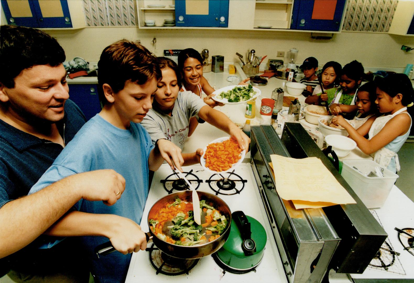 Hands on: Supervised by instructor Chris Stamatopoulos and assisted by classmates, Jesse Langille prepares to stir-fry some vegetables