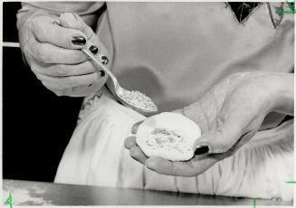 A delight: Mary Fok works on a dim sum treat called Knor Mie chee' (Sweet Glutinous Rice Dumplings) rolling dough, top, and then putting in filling, bottom