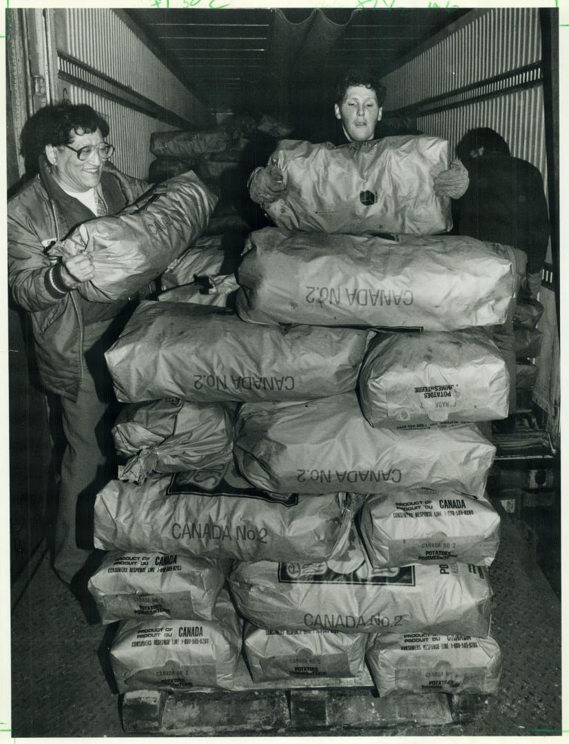 Daily Bread Food Bank workers unload 900 bags of potatoes yesterday after a Metro businessman arranged their delivery from Prince Edward Island