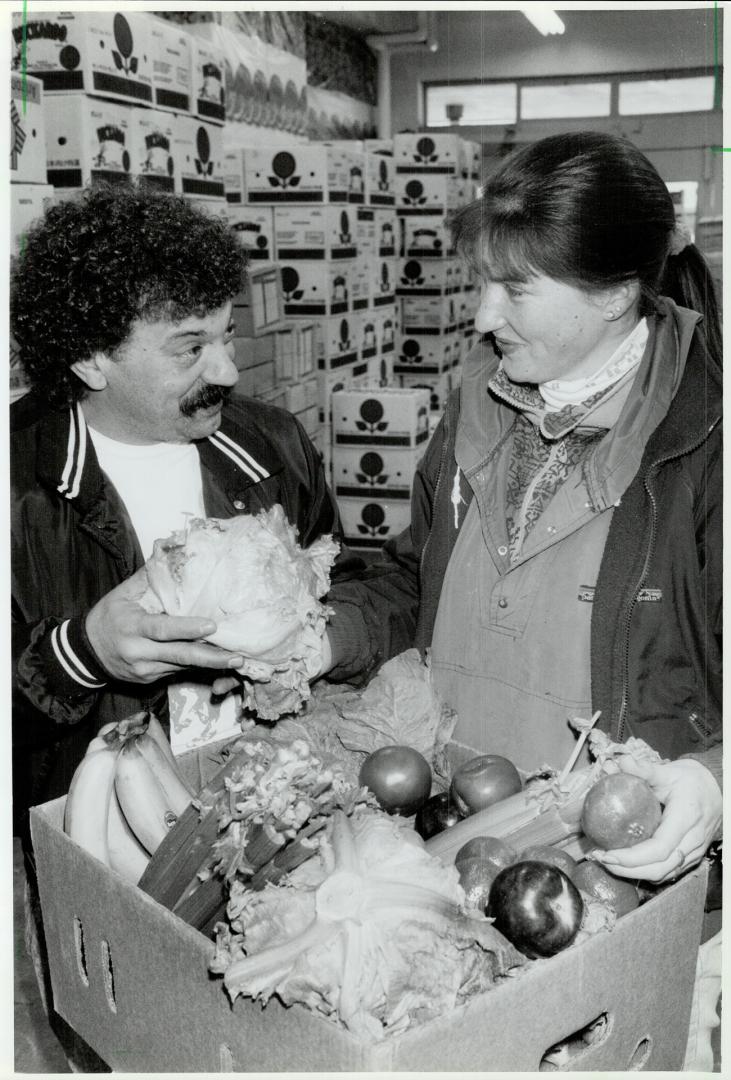 A box of good cheer, Vince Zito and Karen Bobyk pack a banana box with fruit and Vegetables donated by produce wholesalers in the Ontario Food Terminal