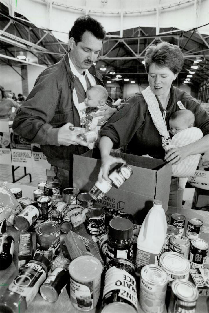 Doubling up: Terry and Cindy Jones of Scarborough pack groceries in Horticultural Building at CNE yesterday with 3-month-old twins Chelsea and Curtis in tow