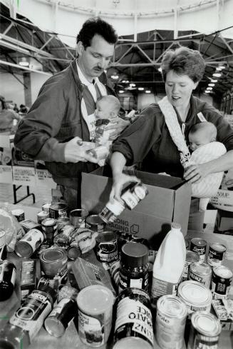 Doubling up: Terry and Cindy Jones of Scarborough pack groceries in Horticultural Building at CNE yesterday with 3-month-old twins Chelsea and Curtis in tow