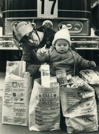 Firefighter John Nearing and 15-month-old Cameron Cotton-O'Brien look over food brought in today by Cameron's mother at No. 17 Fire Hall to help feed (...)