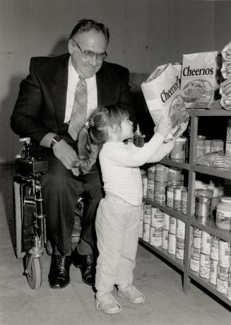 Tot and a box: Alicia Thomson, whose grandmother is a volunteer worker, checks out the stock at the Love in Christ Foodbank started by Shean Campbell in his apartment