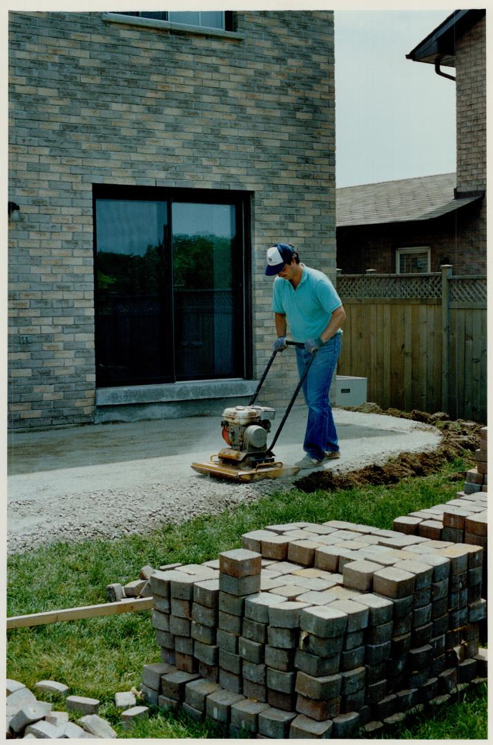 2, After preparing a gravel base, MacLean uses a plate compactor to level it