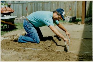 Screeding (levelling and smoothing) the base is done by dragging a plank across sand