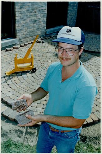 Using a rented stone cutter, MacLean tailors pavers to fill in the gaps