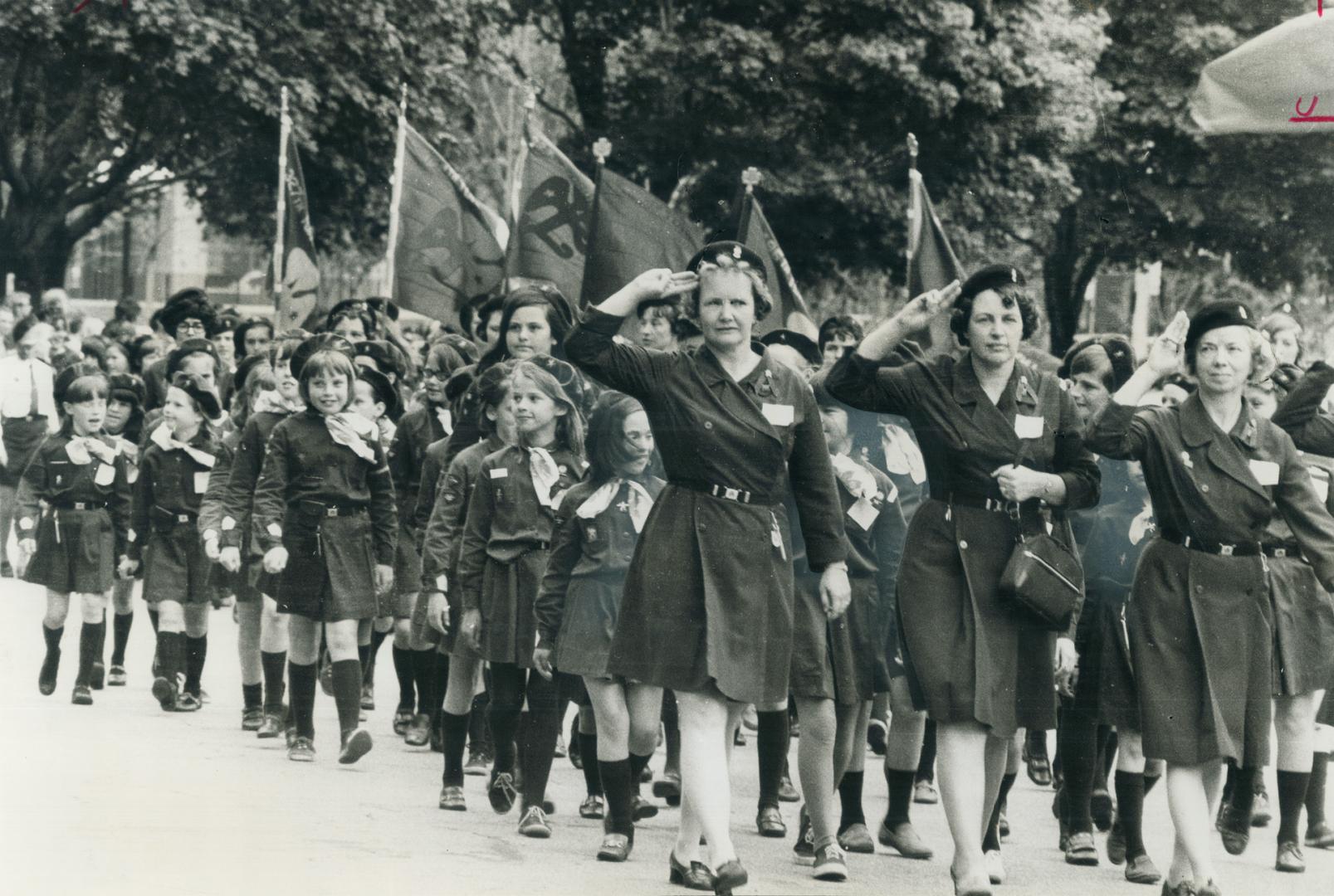 A salute to guides, both to the reviewing stand and to the girl guide organization's 60th anniversary, is given by marchers yesterday as they take par(...)