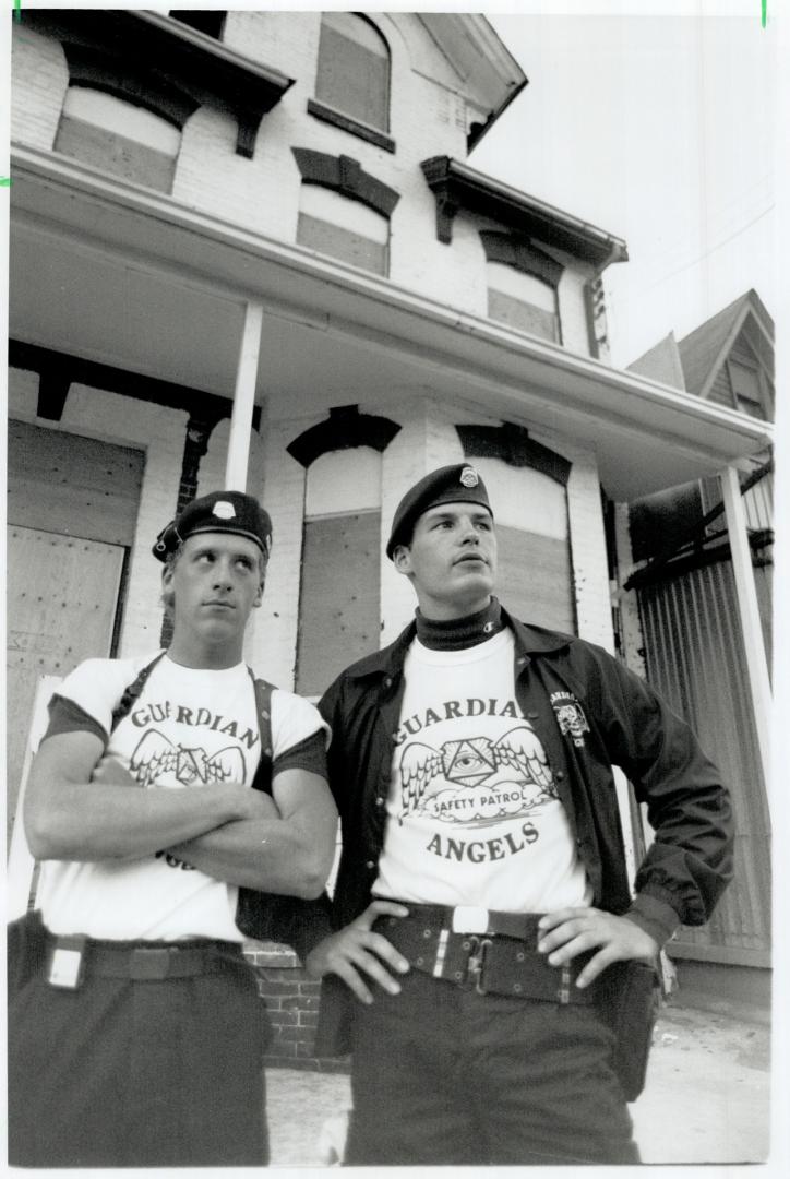 On patrol: Regan Moore, 23, left, and Sebastian Metz, 27, of New York's Guardian Angels stand guard outside a house at Dundas and Ontario Sts