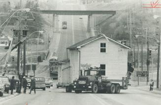 An 1830s Log Cabin, covered with siding in this century, is inched along at Highway 7 and Islington Ave