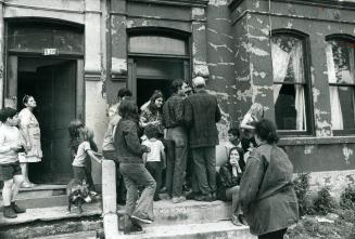 Friends and neighbors block the entrance of a house on Ontario St