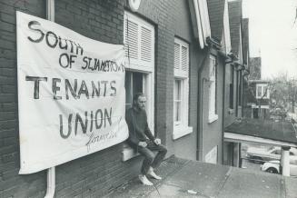 Squatter David Starbuck. Sits on windowsill of room from which he was evicted