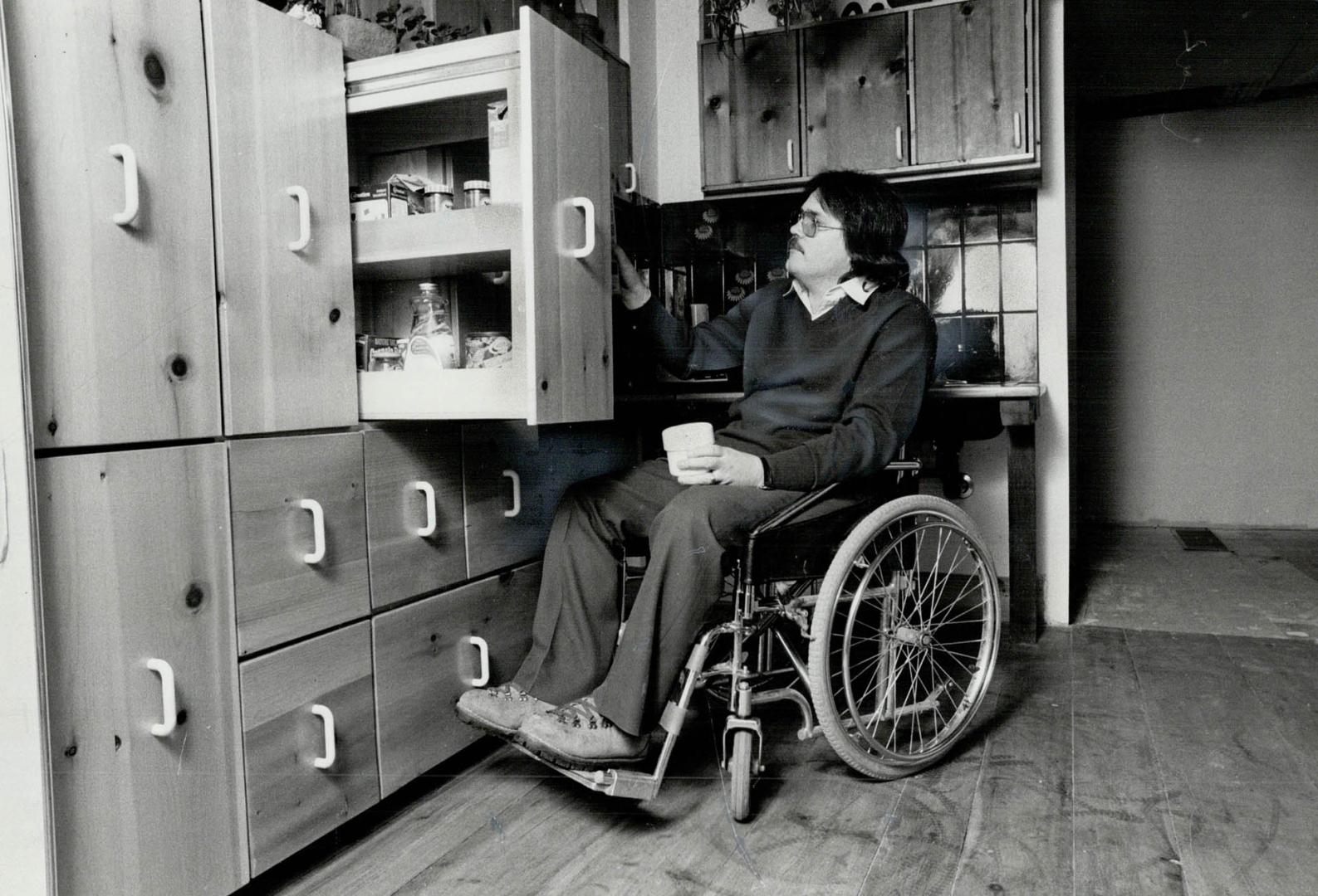 Biggest challenge: The city planner designed a pine cupboard unit (above) with 10 roll-out units that provide about 50 cubic feet of storage space at his level