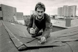 Peak performance: Bill Kirkpatrick, above, and Scott McTaggart, of Al's Roofing in Metro, demonstrate tasks involved in installing a new roof over an old one