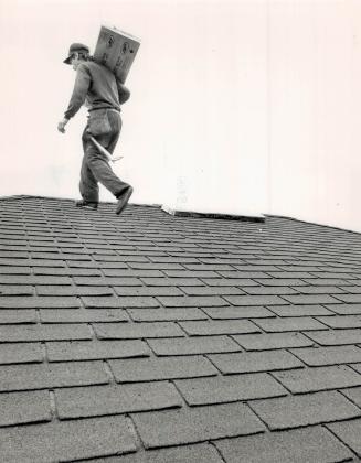 Peak performance: Bill Kirkpatrick, above, and Scott McTaggart, of Al's Roofing in Metro, demonstrate tasks involved in installing a new roof over an old one