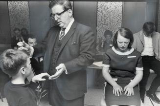 Ralph Albert snaps his fingers to put his nine-year-old son Randall under Hypnosis, His other children, Jane, 13, and Joe, 15, are already under. Behind Mr. Albert is his wife, Clare