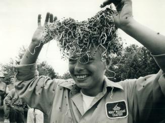 Christine Coy, a worker at Mount Pleasant Cemetery, helps release 35,000 ladybugs yesterday to kill aphids that have taken over the graveyard