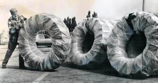 Buddy, can you bowl that tire?, It's hard work moving a 250-pound tractor tire, as longshoreman Donald Mullen, working at dockside in Toronto, discovered recencently