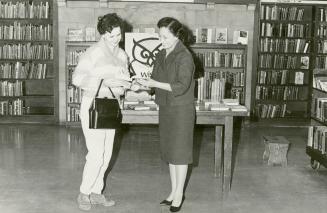 Mrs Leticia Maloles, Colombo Plan trainee from the Philippines, helping a borrower at Beaches Library