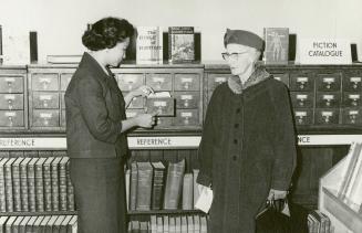 Mrs Leticia Maloles, Colombo Plan trainee from the Philippines, helping a borrower with the card catalogue at Beaches Library