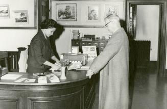 Mrs Leticia Maloles, Colombo Plan trainee from the Philippines, marking out a borrower's book, Beaches Library (autumn, 1960)