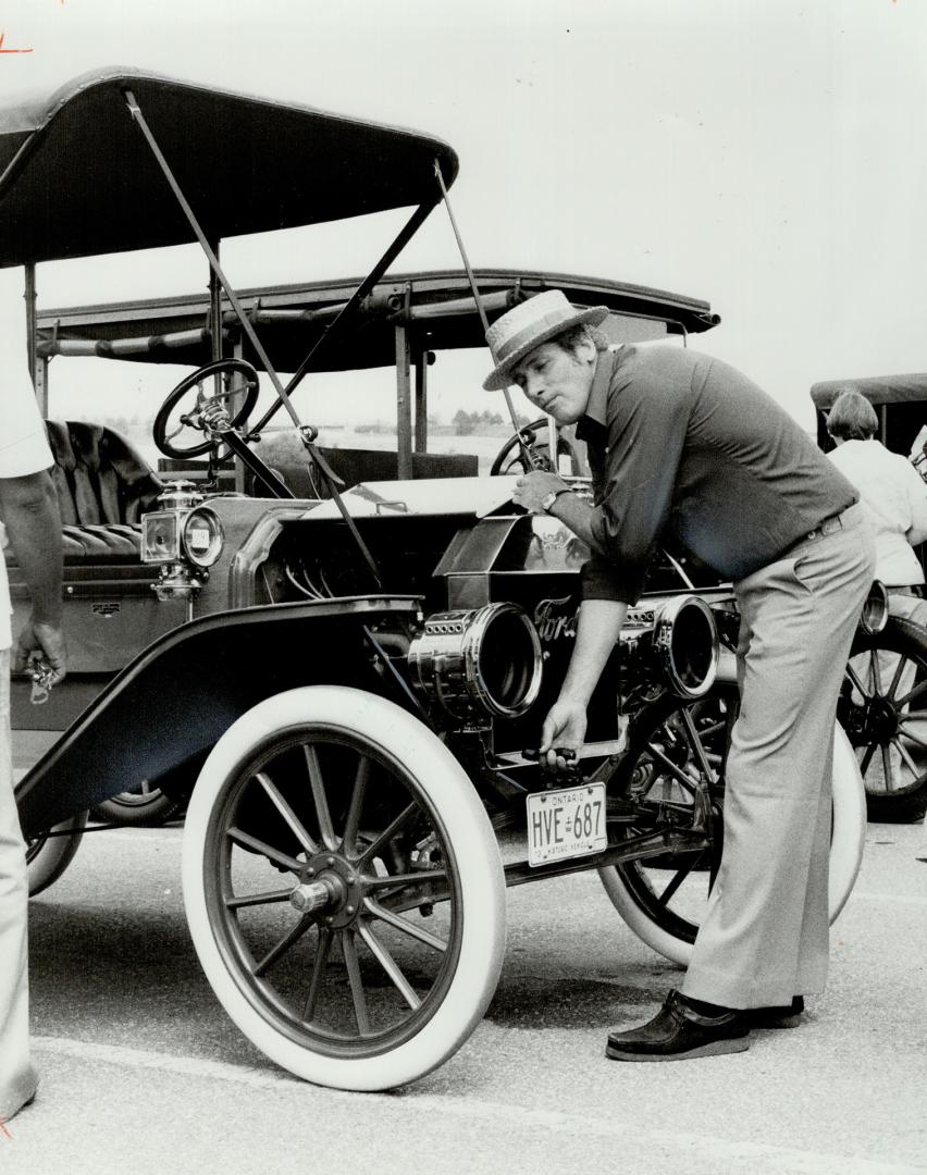 T'ing off, Ron Simon of Waterford cranks up the oldest running Model T Ford in Canada, a 1909 touring car, at Ford Canada 75th anniversary celebrations in Oakville yesterday