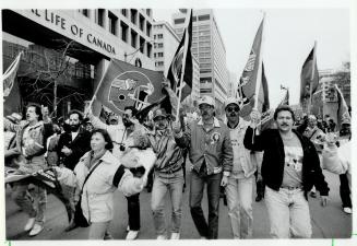 A boisterous group (below) carries the flag for the Roughriders down the University Ave