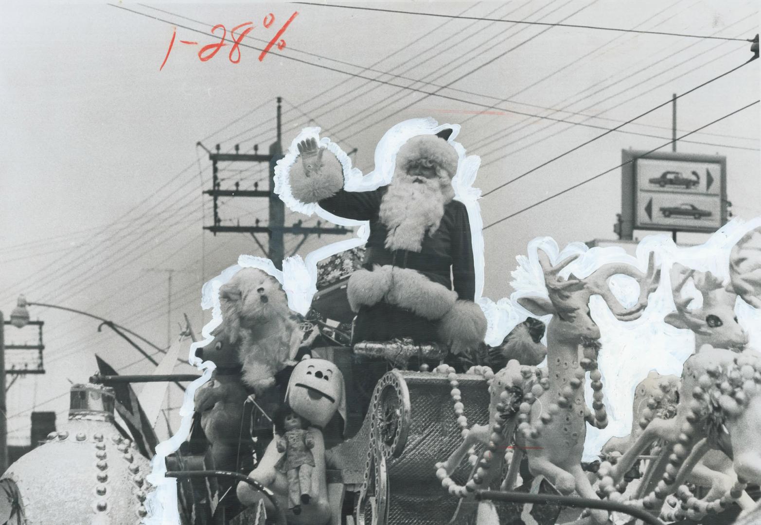 The star of the show, grand old Santa waves from atop his reindeer-powered chariot, the final float in the mile-long Santa Claus parade through Toront(...)