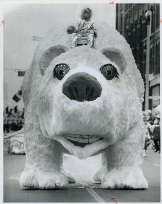 Gigantic polar bear is ridden bareback by one of the youngest helpers