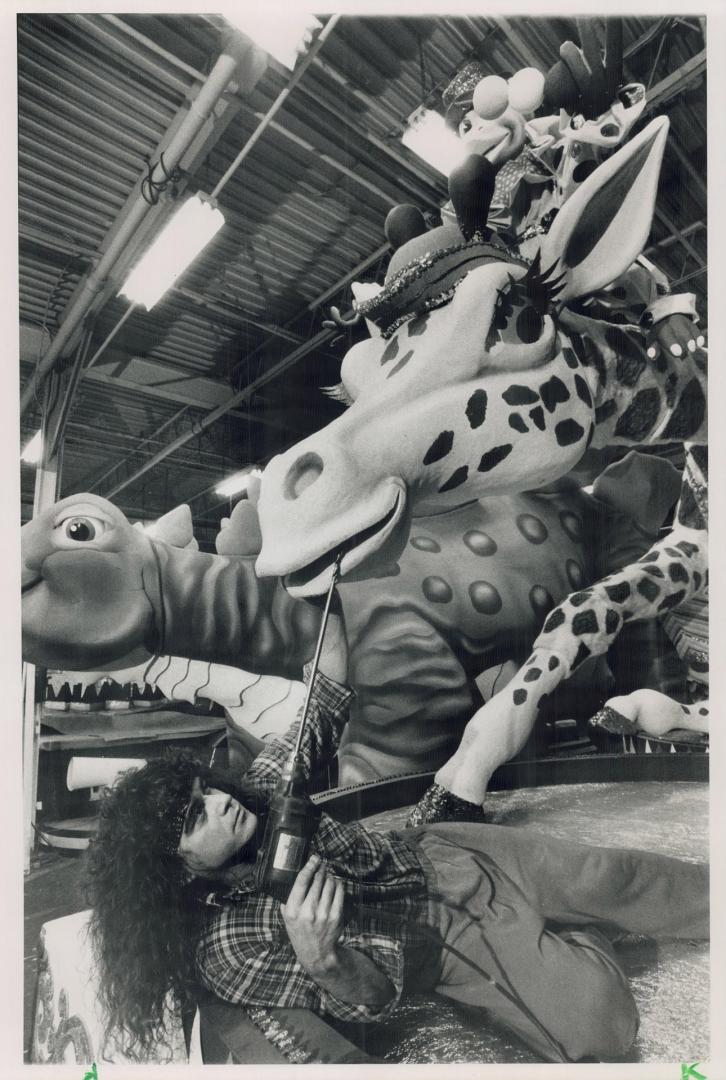 Last-minute dental work, Artist and sculptor Peter Brown does a last-minute touch-up on a giraffe for a float in tomorrow's Santa Claus parade. The annual event begins at 1 p.m